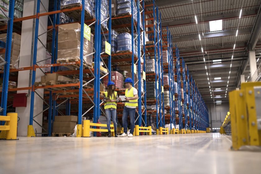 Warehouse workers discussing about logistics and distribution packages to the market.