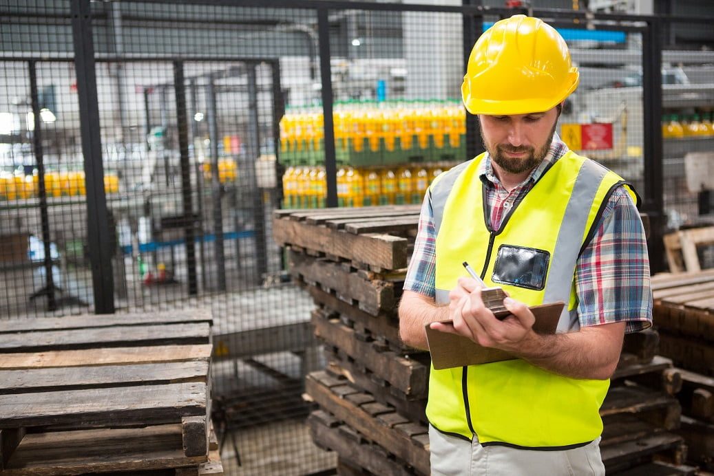 Confident male worker noting about products in warehouse